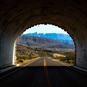 a digital image looking through a darkened tunnel to the bright chihuahuan desert scenery beyond in big bend national park