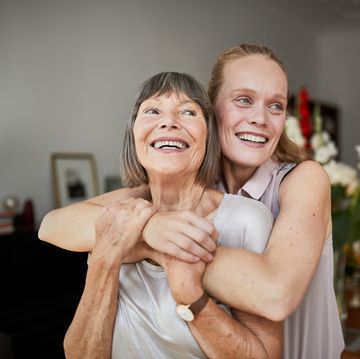 cheerful mature woman embracing senior mother at home and looking away portrait of elderly mother and middle aged daughter smiling together