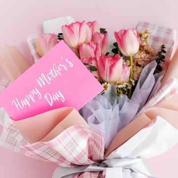 bouquet of pink tulips and other flowers wrapped in plaid paper with a pink card reading happy mothers day in white script