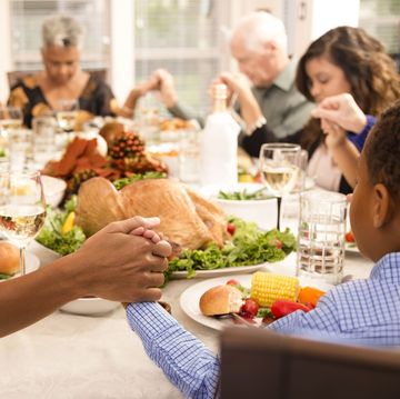 family prays at thanksgiving table holding hands