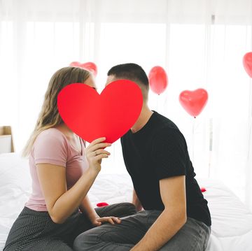 couple kissing behind heart